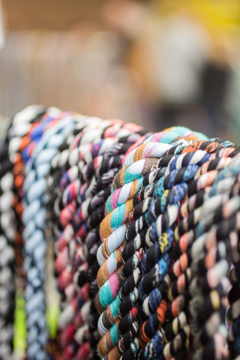 Colorful braided bracelets on a stand with a blurred background