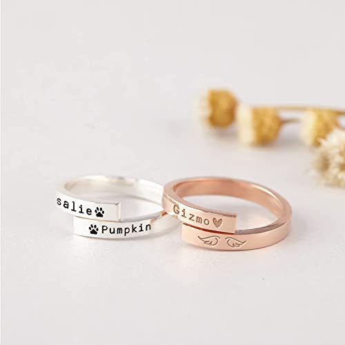 Two rings, one silver and one rose gold, with engraved names on a light background.