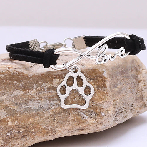 Bracelet with paw charm and 'love' inscription on a piece of wood