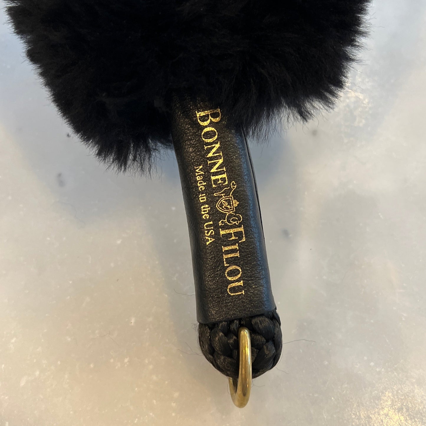 Black fluffy brush with 'Bonne Etélè' branding on a light background
