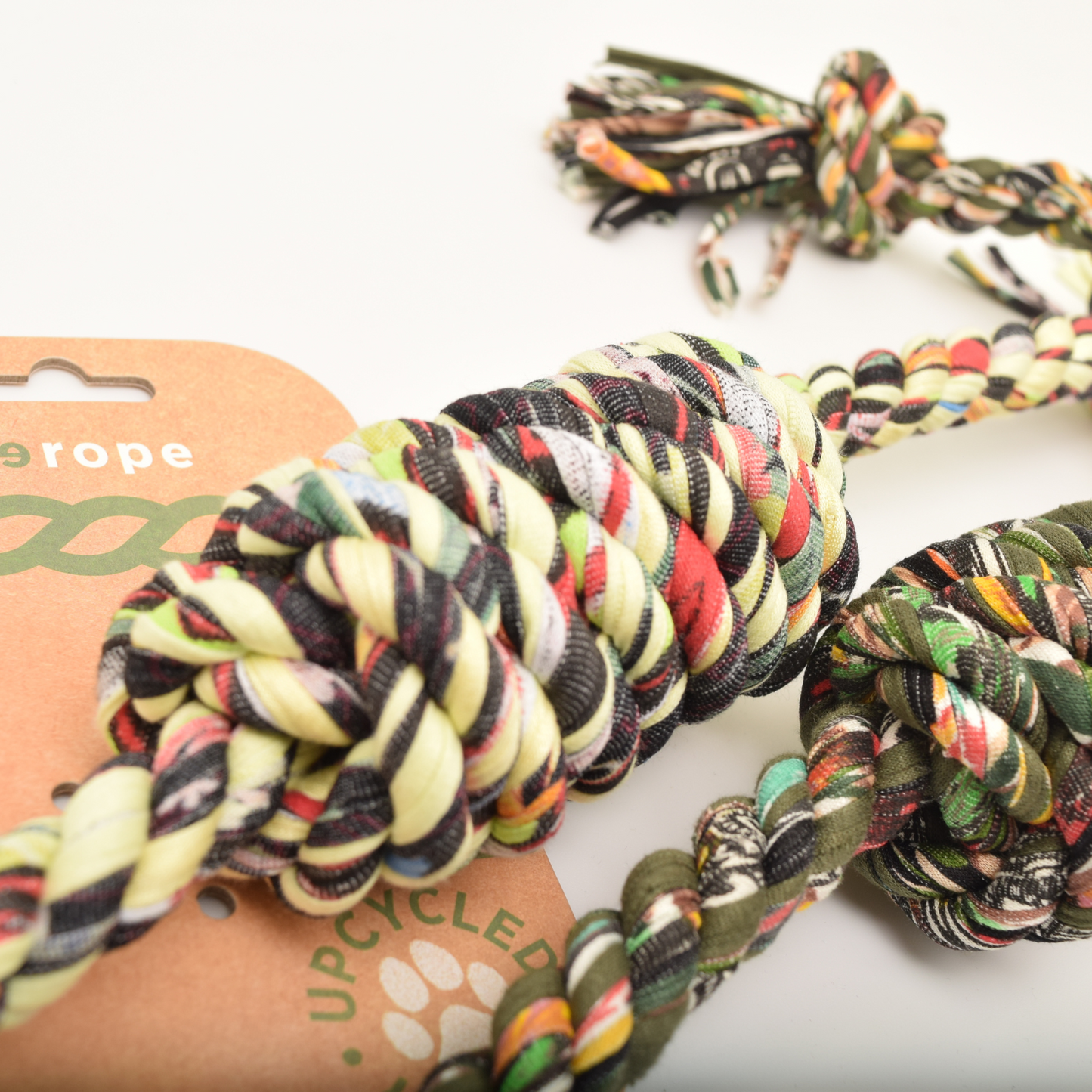 Colorful braided rope toy with a brand card in the background