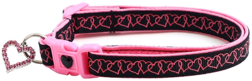 Pink and black dog collar with heart pattern on a white background