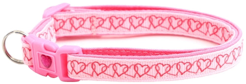 Pink dog collar with heart pattern on a white background
