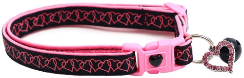 Pink and black dog collar with heart design and keychain on a white background
