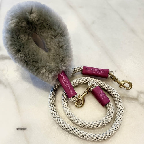 Dog collar with fluffy texture and braided leash on a white background