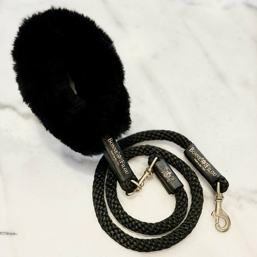 Black dog leash with a fluffy black handle on a white background
