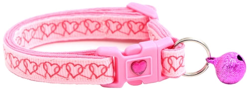 Pink dog collar with heart patterns and a bell on a white background