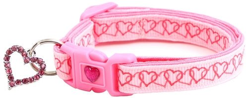 Pink dog collar with heart pattern and keychain on a white background