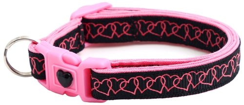 Pink and black dog collar with heart pattern on a white background