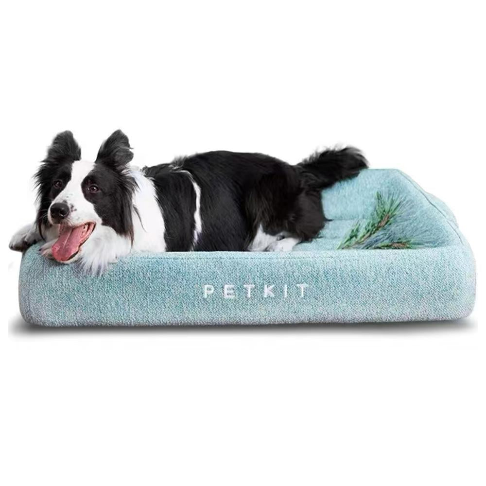 Dog lying on a blue pet bed with 'PETKIT' branding on a white background