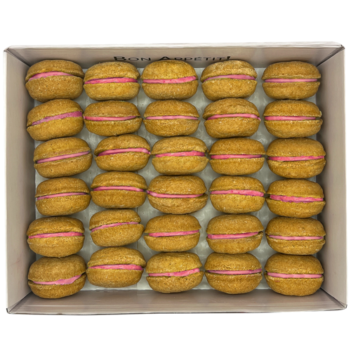 Box of cookies with pink filling on a white background