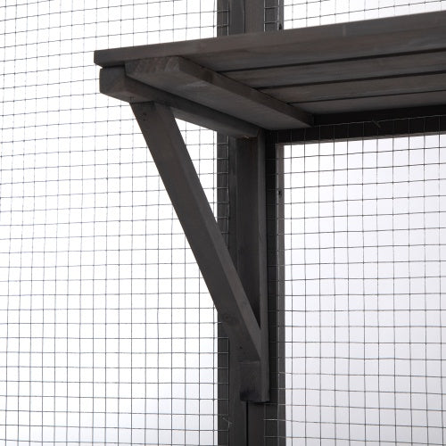 Wooden pergola structure with metal support beams against a wire fence background