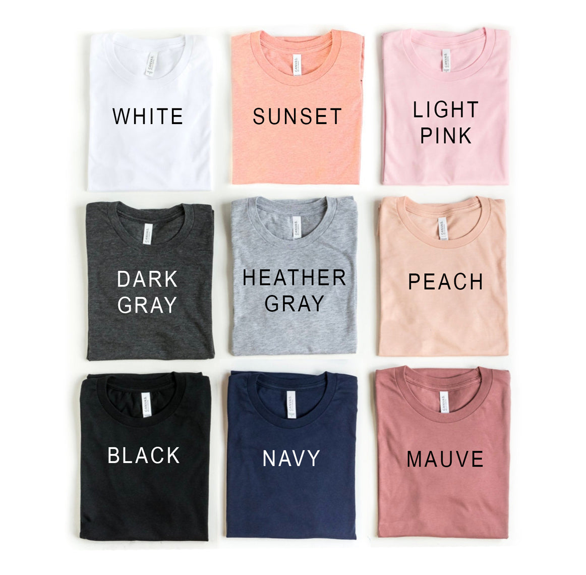 Collection of folded t-shirts in various colors with labels on a white background