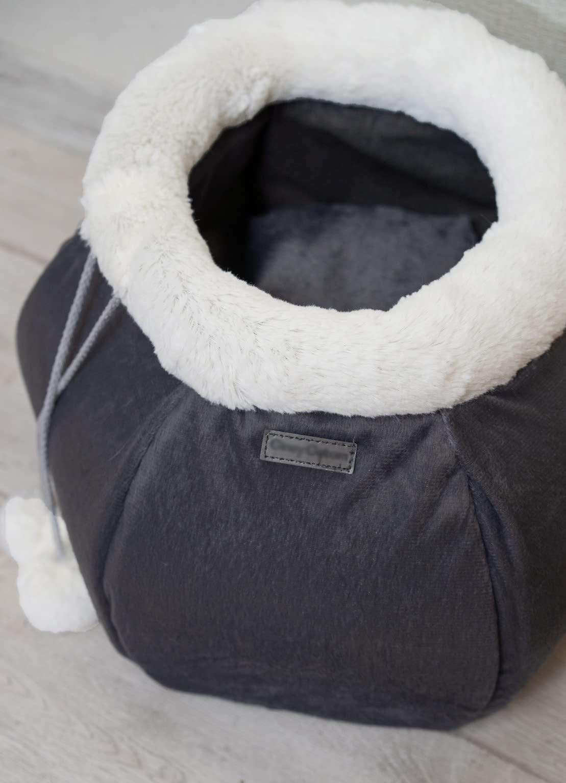 Gray pet carrier with white interior on a light wooden floor