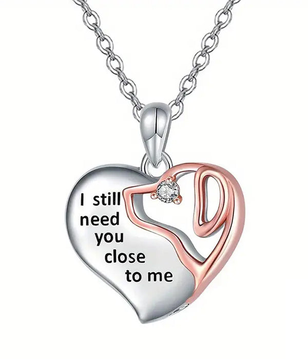 Heart-shaped pendant necklace with engraved message on a white background