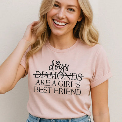 Woman wearing a pink t-shirt with text 'dogs diamonds are a girl's best friend' on a plain background