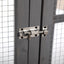 Metal door latch on a gray door with tiled walls in the background