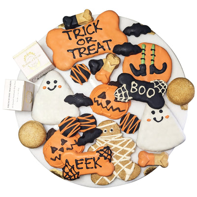Halloween-themed cookies on a plate with 'Trick or Treat' and 'Boo' text.