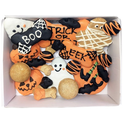 Box of Halloween-themed cookies with various designs including pumpkins, ghosts, and text.