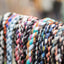 Colorful braided bracelets on a stand with a blurred background