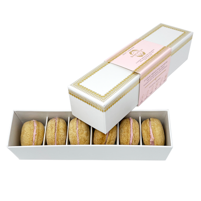 Box of macarons with a pink filling on a white background