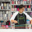 Man working with colorful ribbons in a store filled with spools of ribbon.