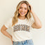 Woman wearing a 'DOG MOM' t-shirt against a plain background