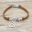 Bracelet with paw charm and 'love' infinity symbol on a wooden surface
