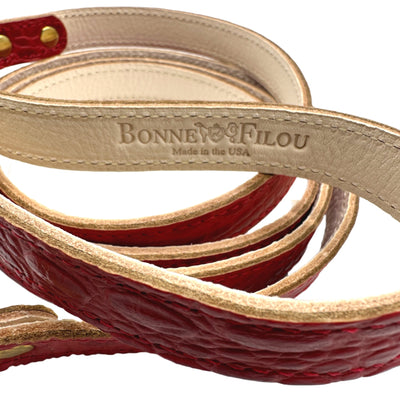 Coiled red and beige leather dog leash with 'Bonnie & Filou' branding on a white background