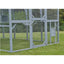 Large outdoor bird cage with mesh sides on a grassy area