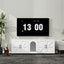 Digital clock displaying the time and date on a wall in a room with a dog and plant.