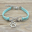 Turquoise bracelet with silver paw charm and 'love' infinity symbol on a wooden surface