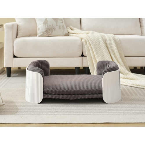 Gray pet bed in a living room setting with a sofa and rug.