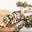 Colorful braided rope toy with a brand card in the background
