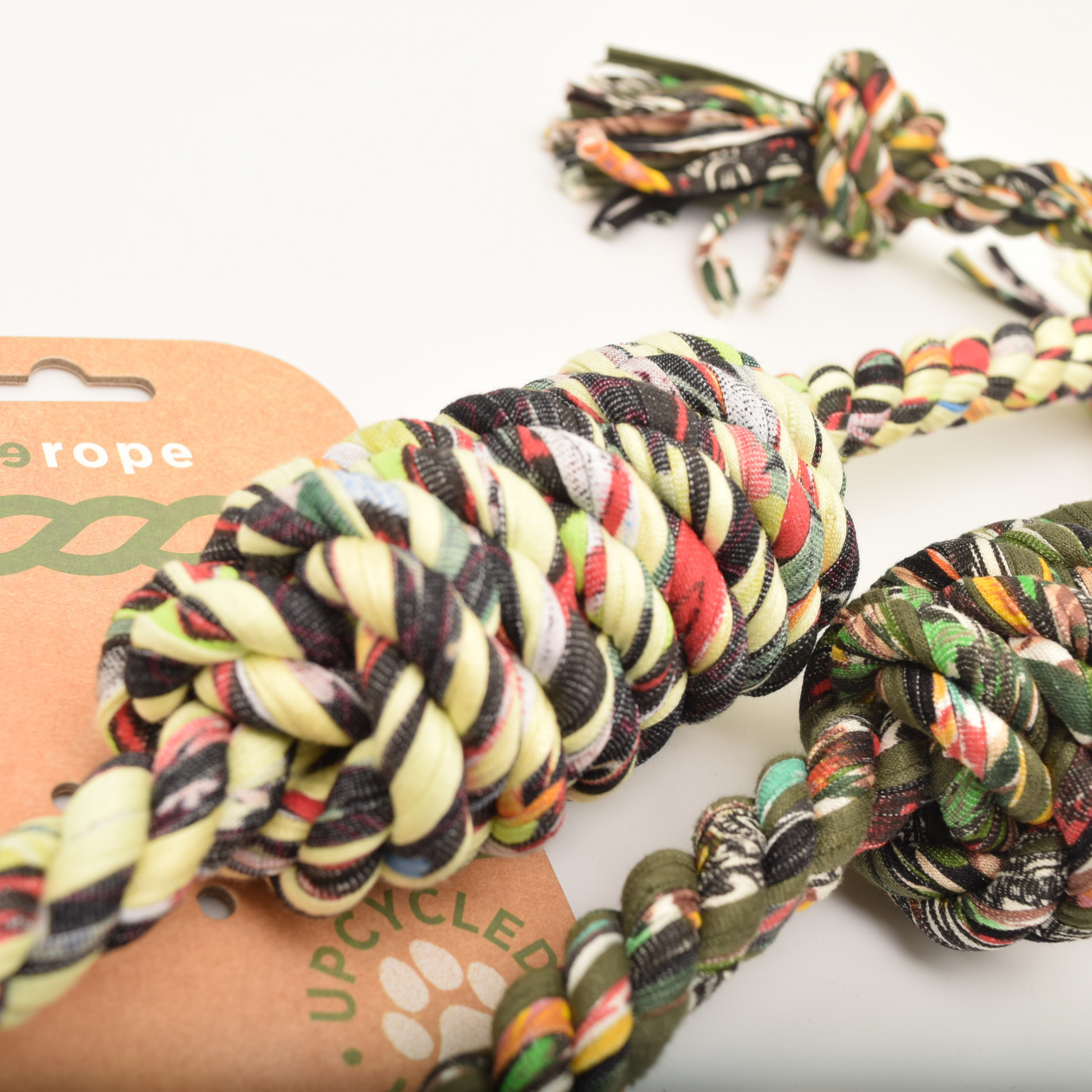 Colorful braided rope toy with a brand card in the background