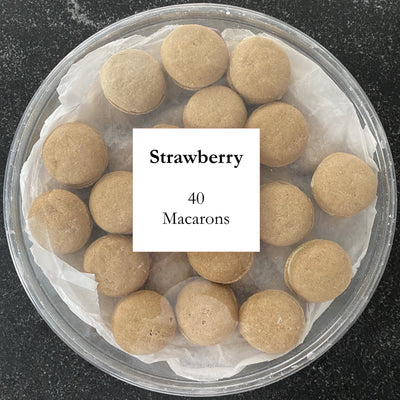 Container of macarons with a label indicating 'Strawberry' and '40 Macarons' on a dark surface.