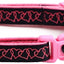 Pink dog collar with black heart pattern on a white background