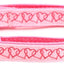 Pink dog collar with heart pattern on a white background