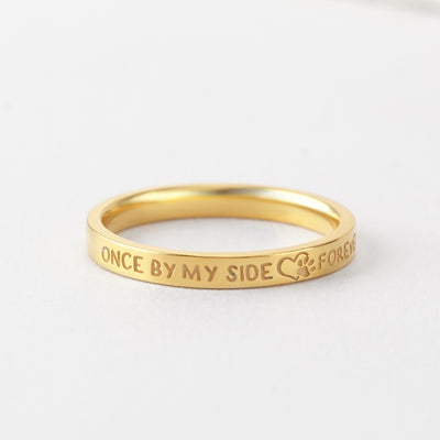 Gold ring with engraved text on a white background