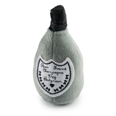 Plush toy shaped like a champagne bottle with a label on a white background