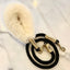 Black dog leash with fluffy white handle on a marble surface