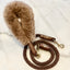 Brown braided dog leash with fluffy brown handle on a white background