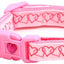 Pink dog collar with heart pattern and keychain on a white background
