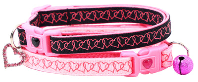 Pink and black dog collar with heart patterns and a bell on a white background