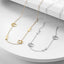 Two gold and silver paw print necklaces on a white surface.