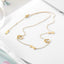 Gold necklace with paw and cross charms on a white background