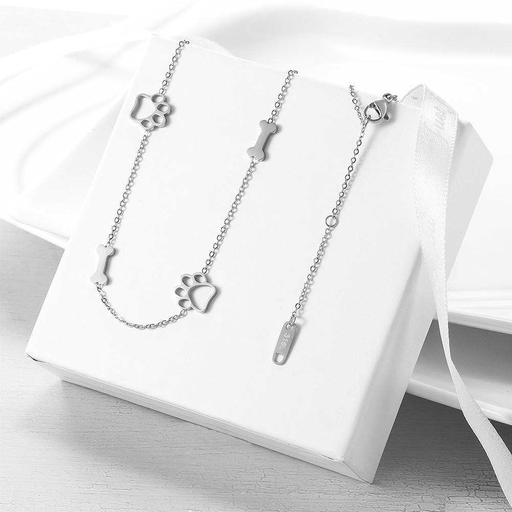 Silver paw print and bone-shaped jewelry on a white box