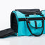 Turquoise pet carrier with black straps on a white background