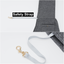 Gray dog leash with gold clip attached to a gray jacket, labeled 'Safety Strap'.