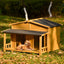 Wooden doghouse with a dog inside on a grassy outdoor setting
